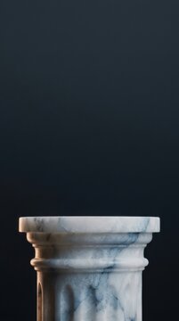 Carved alabaster column with intricate details against a dark background, showcasing classical architectural design elements and textures