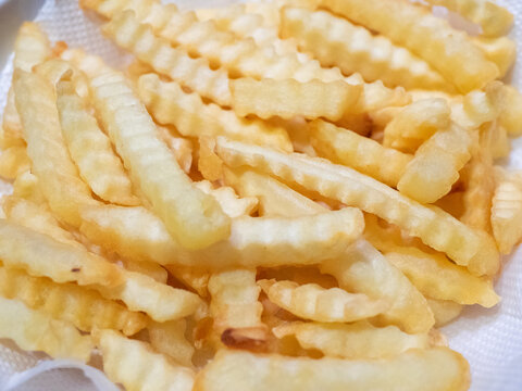 Crinkle cut french fries potatoes fried in hot oil