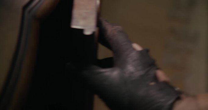 Close-up of a mysterious gloved hand removing a brown envelope from a drawer in dark shadows, evoking clandestine activity, espionage and spy thriller storytelling.