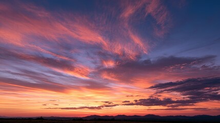 Fototapeta premium Twilight sky with high-contrast colors and dramatic cloud textures over distant silhouettes