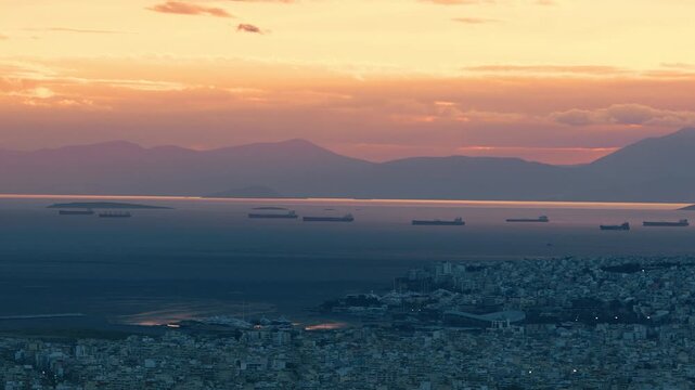 Aerial panoramic view at residential areas of Athens and Piraeus port with anchored boats in Greece during breathtaking sunset