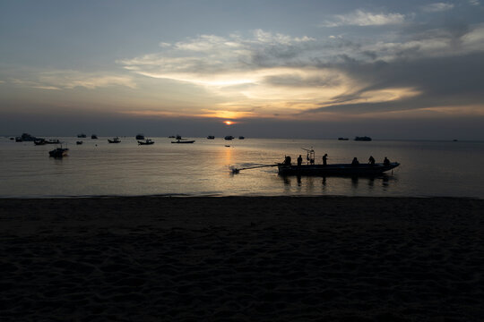 Fishing Boat Silhouette at Sunset on Calm Tropical Sea with Anch