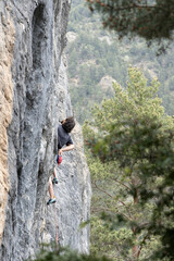 Rock Climber Scaling Steep Granite Cliff Face with Orange Rope a © Guillermo