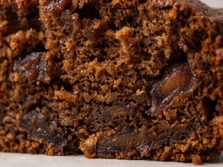 Fototapeta premium Macro shot of moist textured fruitcake crumb with dark dried fruit pieces