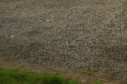 Close up view of dry sandy soil and gravel ground texture in open field