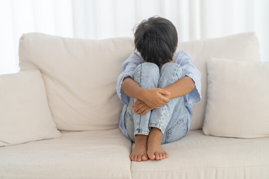 Bullying awareness, sad asian boy sitting alone hugging knees, child mental health, psychological trauma, emotional distress, depression symptom, social isolation, school violence and silent victim