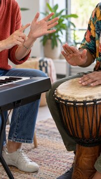 Adults practicing rhythm with keyboard and djembe