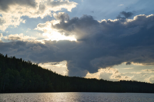 Dramatic Sunset Over Calm Lake and Wooded Hill, in sweden, smaland.