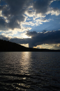 Dramatic Sunset Over Calm Lake and Wooded Hill, in sweden, smaland.