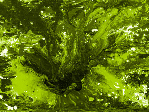 Abstract art background with dynamic splashes and swirls of vibrant lime green, olive, and deep black acrylic paint.