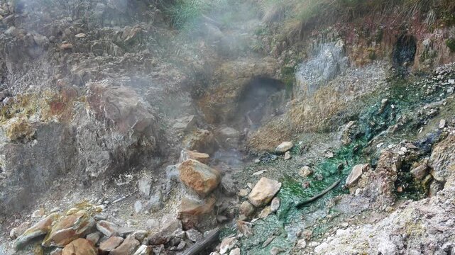Geothermal springs in Tuscany, Italy, with mineral-rich rocks, steaming ground, and vivid green thermal deposits, showcasing volcanic activity, natural energy, and unusual landscape formations