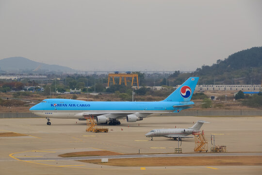 A Korean Air Cargo Boeing 747 freighter waits on the apron at dusk with mountains behind on October 26, 2017 in South Korea.