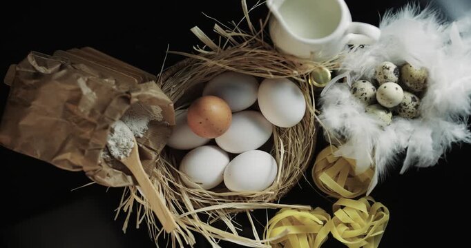 A basket of eggs and a bag of flour sit on a table
