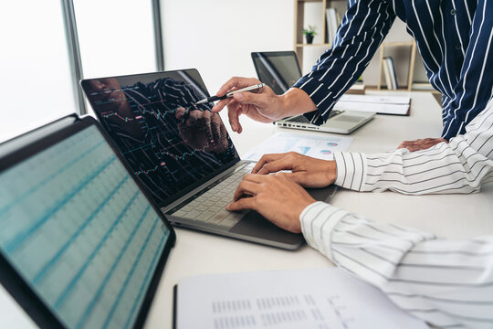 Business trader team are using laptop to checking stock market o