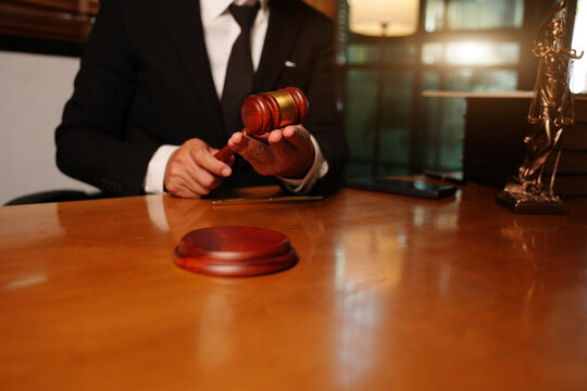 Lawyer or Judge Holding Wooden Gavel at Office Desk