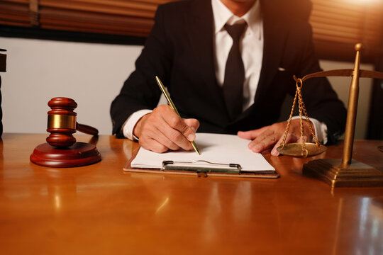 Asian Lawyer Writing on Contract Document in Legal Office Environment