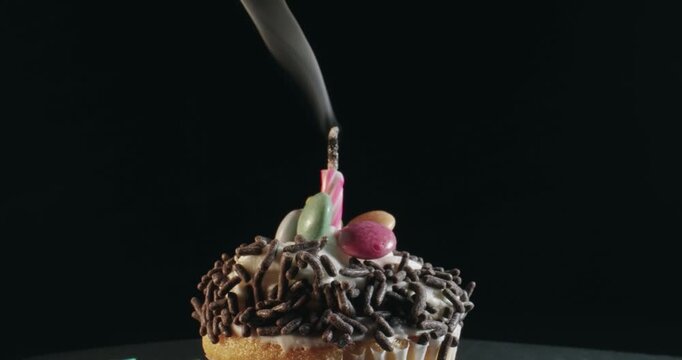A cupcake with a lit candle and smoke on top