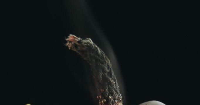 A lit candle is shown with its tip in the air