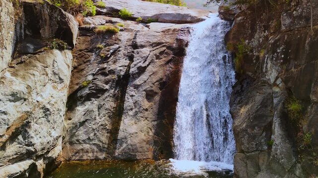 Static aerial view of Likhubula Falls flowing in slow motion over a rugged rock face in Mulanje Massif, Malawi.