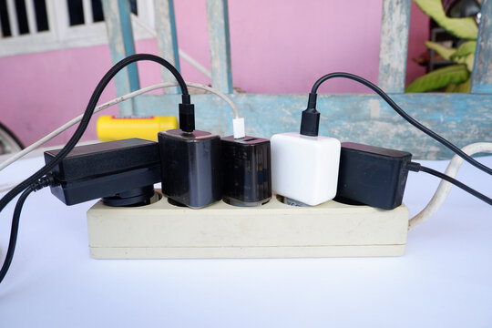 Overloaded Power Strip with Multiple Chargers and Plug Adapters