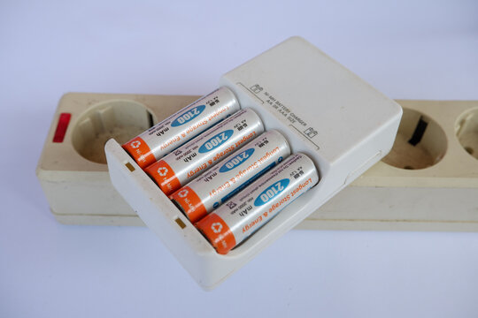 Recharging AA Batteries in Portable Charger on Electrical Power Socket Strip for Electronic Device Energy Supply