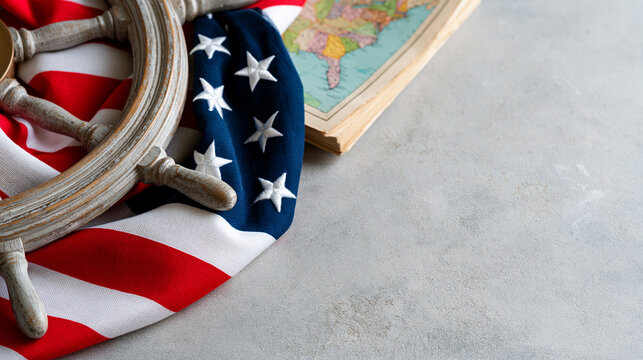Columbus Day greeting composition with a vintage ship wheel, folded American flag fabric and antique map on a neutral stone surface, patriotic maritime heritage, flat lay, premium