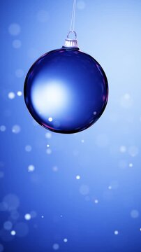 Hanging blue Christmas bauble with soft bokeh vertical loop