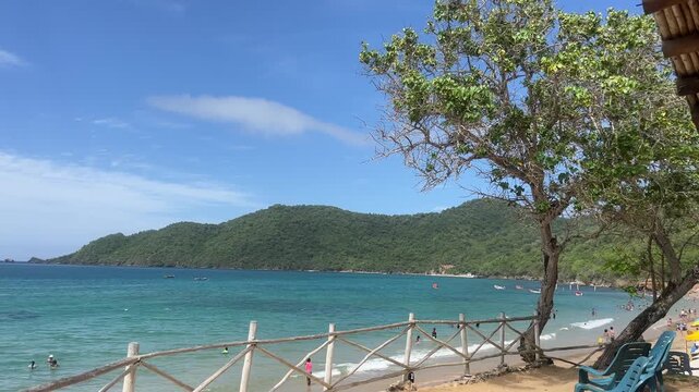 Tropical beach bay with turquoise water and wooden fence