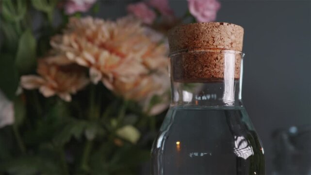 Refilling glass carafe with fresh water and closing with cork stopper