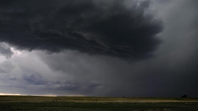 Dramatic timelapse captures massive storm cell clouds rolling over wide open US plains, showcasing intense weather patterns, shifting light, and ominous skies.