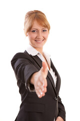 Confident blonde businesswoman reaching hand out for handshake looking at camera with focus on face isolated on white background. © Fatih