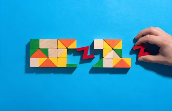 Colorful geometric wooden puzzle pieces on bright blue background with hand placing red zigzag block, symbolizing logical thinking and problem solving  generated ai