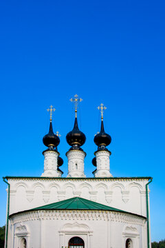 Black Onion Domes with Golden Crosses of Russian Orthodox Church Against Vibrant Clear Blue Sky