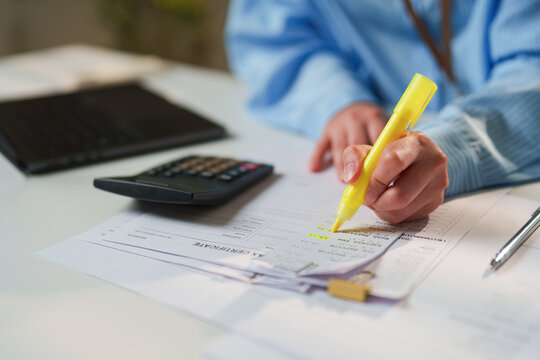 Auditor highlighting deductible expenses on an itemized receipt and tax certificate at a clean office desk, certified public accountant services, corporate tax compliance, and forensic audit diligence