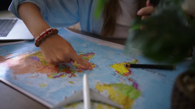 Female traveler research destinations on world map with magnifying glass while plan budget-friendly vacation, use piggy bank, model airplane to represent smart travel decisions, savings, preparation