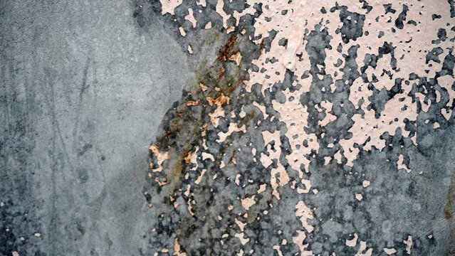 Aged gray wall with peeling paint and rust marks.