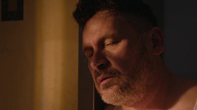 Middle aged Caucasian man sweating and looking distressed during alcohol withdrawal. Ideal for substance abuse rehabilitation campaigns and mental health awareness projects