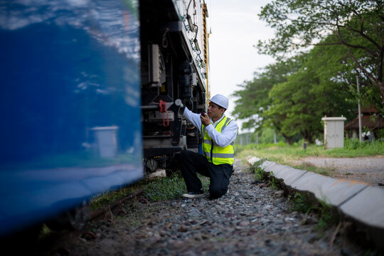 Railway Maintenance Worker Inspecting and Repairing Train Tracks Outdoors