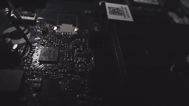 A close up of a computer part with a yellow light on it. The image is in black and white and has a moody, mysterious feel to it