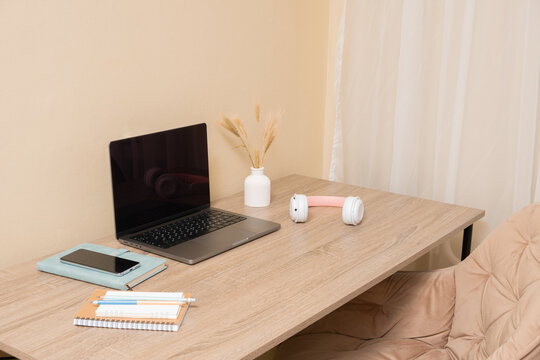 Modern workspace with laptop, smartphone, and headphones on desk