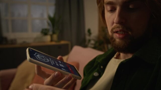 Caucasian young man talking on smartphone while holding credit card during bank security call. Footage suits cyber fraud prevention, online banking safety, and fintech campaigns