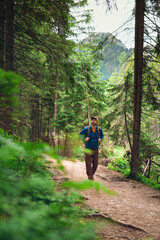Fototapeta premium A man hiking in the mountains and looking at the beautiful scenery.