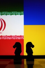 Iran and Ukraine flags behind chess pieces. Geopolitical conflict, military intelligence, and international relations. © Blossom Stock Studio