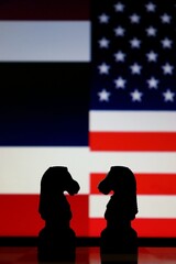 Thailand and United States flags behind chess knight pieces. Diplomatic strategy and trade negotiations. © Blossom Stock Studio