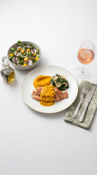 Til&aacute;pia grelhada com molho de pequi, pur&ecirc; de ab&oacute;bora, salada fresca e vinho ros&eacute; em composi&ccedil;&atilde;o gourmet vista de cima