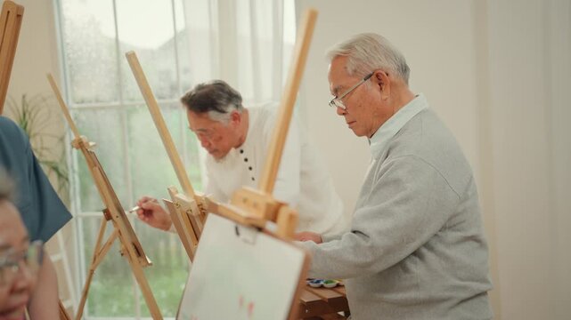 Senior elderly mental health art therapy caregiver painting studio active aging support in bright studio with group painting practice and calm focus for social support and creative well being