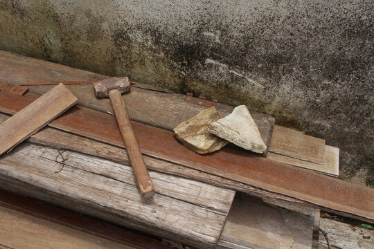Sledgehammer tool and some rocks on top of wood scraps. Horizontal shot with copy space, ideal for building, construction, mason work, woodworking and capentry.