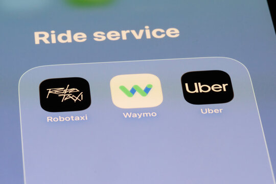 Shanghai,China-Sep.6th 2026: ride-hailing and autonomous driving app icons on phone screen, featuring Tesla Robotaxi, Waymo, and Uber