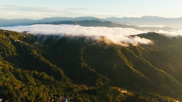 Leftward drone reveals sunrise clouds hugging Baguio mountains, Benguet