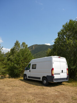 White Camper Van in Mountain Forest